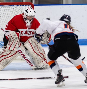 St. Paul's goalie Madison Beck has a Milton forward bearing down on her.